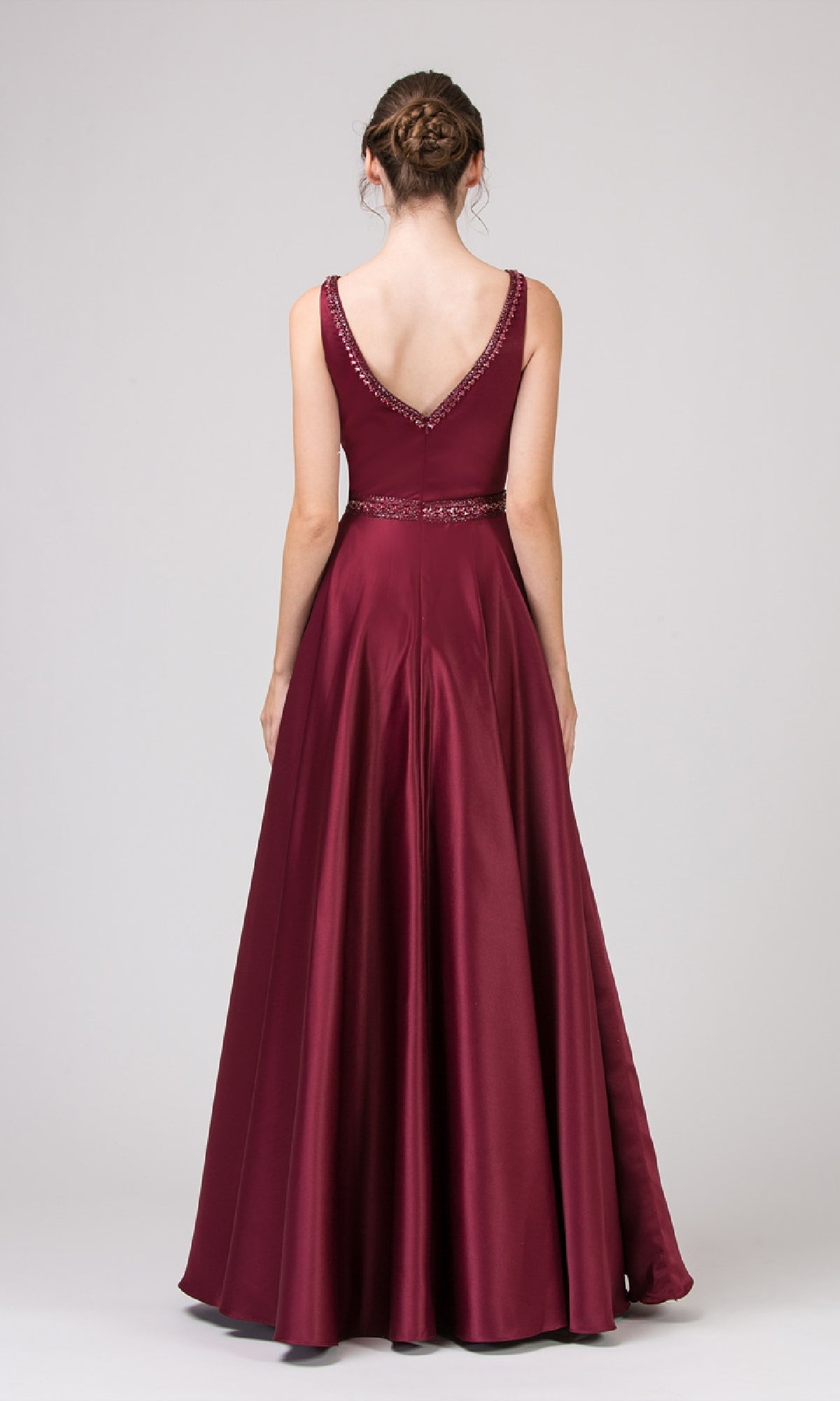 A woman faces away from the camera in the Beaded-Waist Long Satin Prom Dress Eureka 9010, a sleeveless, floor-length burgundy gown featuring a V-shaped back and beaded waist, set against a plain light gray background.